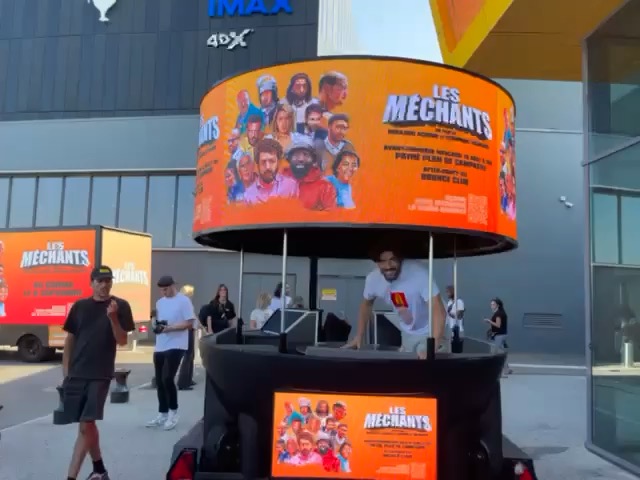 Mirage Ball wrapped with the Les Méchants film poster in front of a cinema